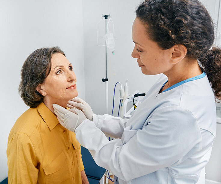 female doctor feeling neck of patient